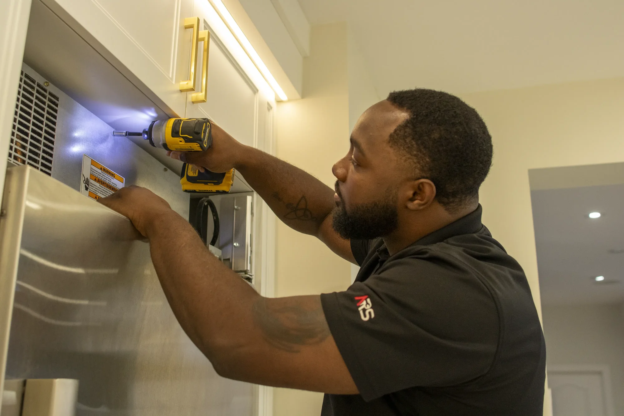Technician servicing a refrigerator freezer Technician servicing a refrigerator freezer