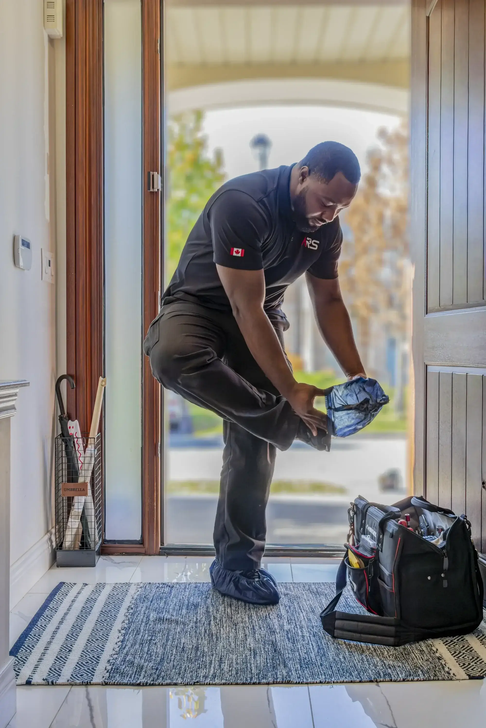 Appliance Repair Technician Wearing Shoe Covers at Home Entrance